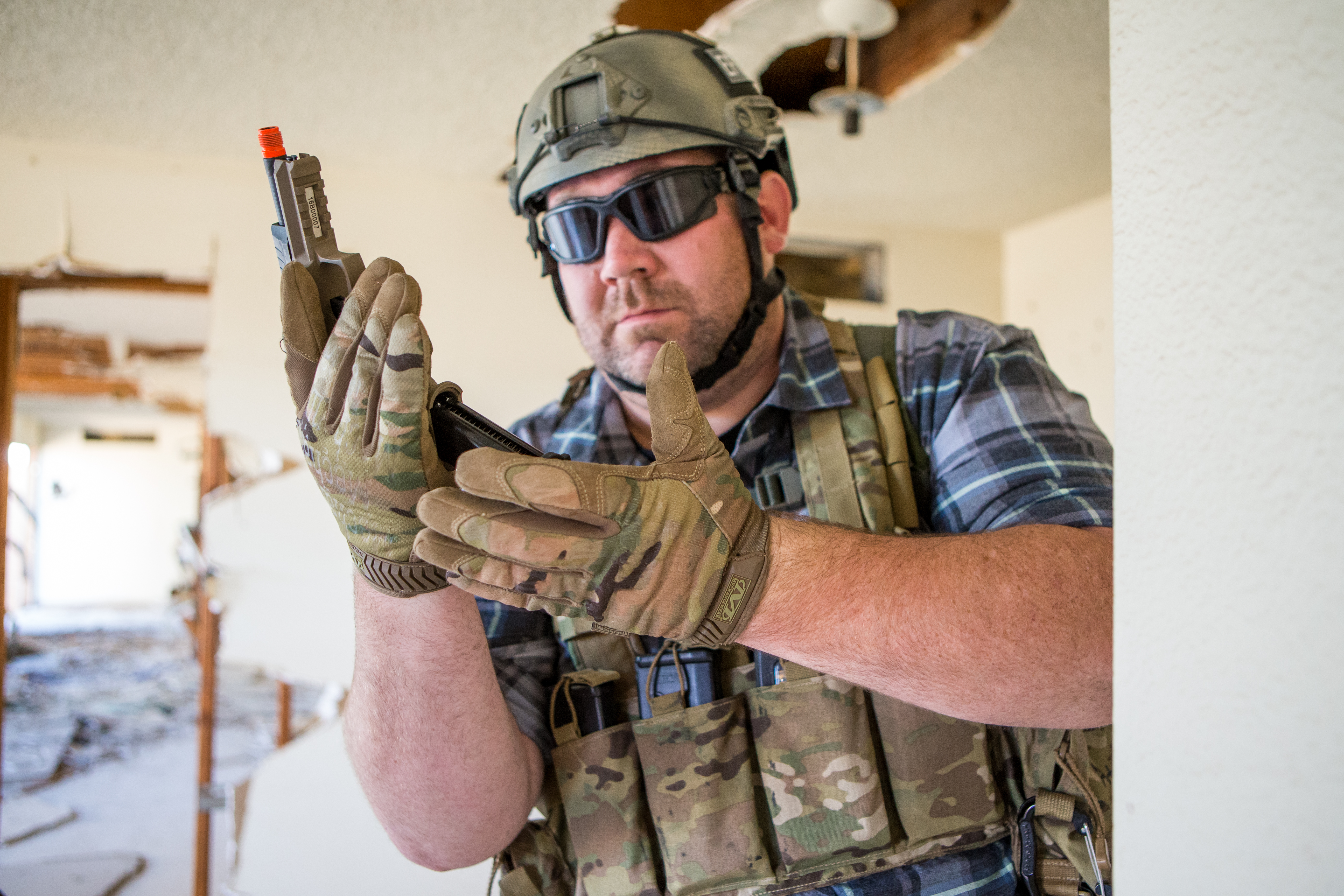 Airsoft player Nigel Iles inserting a magazine into an airsoft pistol
